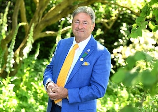 Alan Titchmarsh in a suit with garden background 