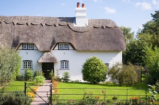 A countryside cottage with a vibrant green lawn 